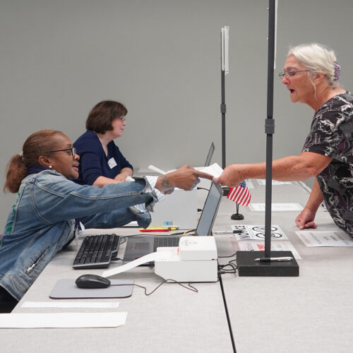 A Catawba County, NC voter receives the state-required absentee voting application as the first step to checking in for early voting during the 2021 primary election.