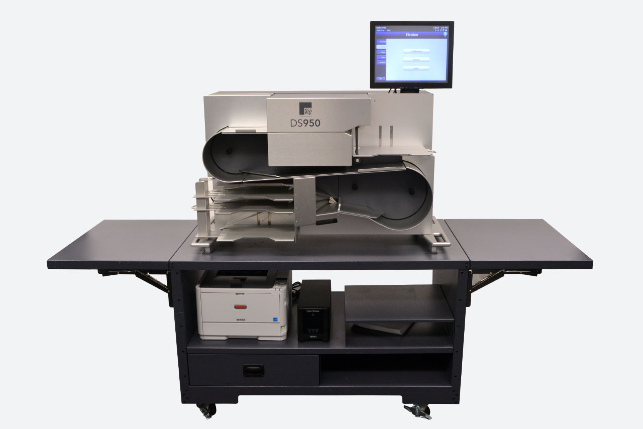 DS950 on its cart, with wings extended for additional ballot prep workspace. Report printer and uninterruptible power supply (UPS) shown on the cart's middle shelf.