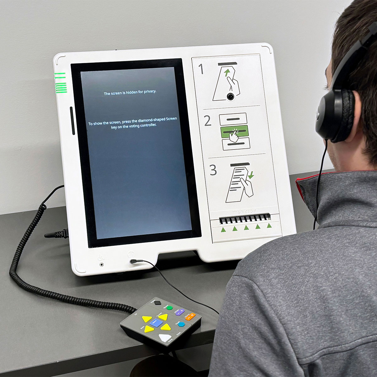 An ExpressVote with the screen blanked while the voter listens to audio prompts to navigate the voting process.