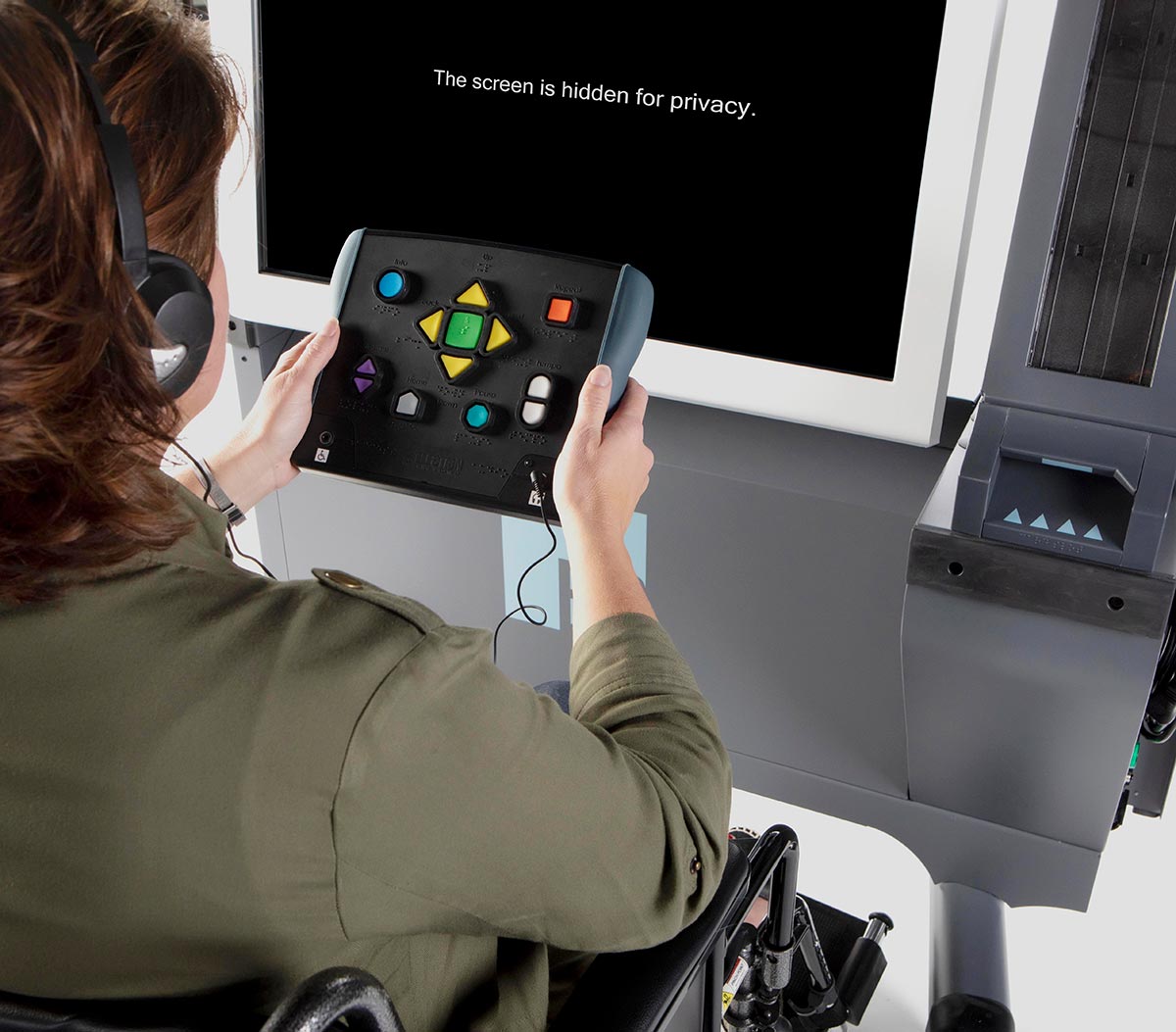 ExpressVote XL, voter with UVC and screen hidden for privacy A voter using the ExpressVote XL audio-tactile keypad, listening to the ballot text by wearing headphones, while the screen is blacked out for privacy